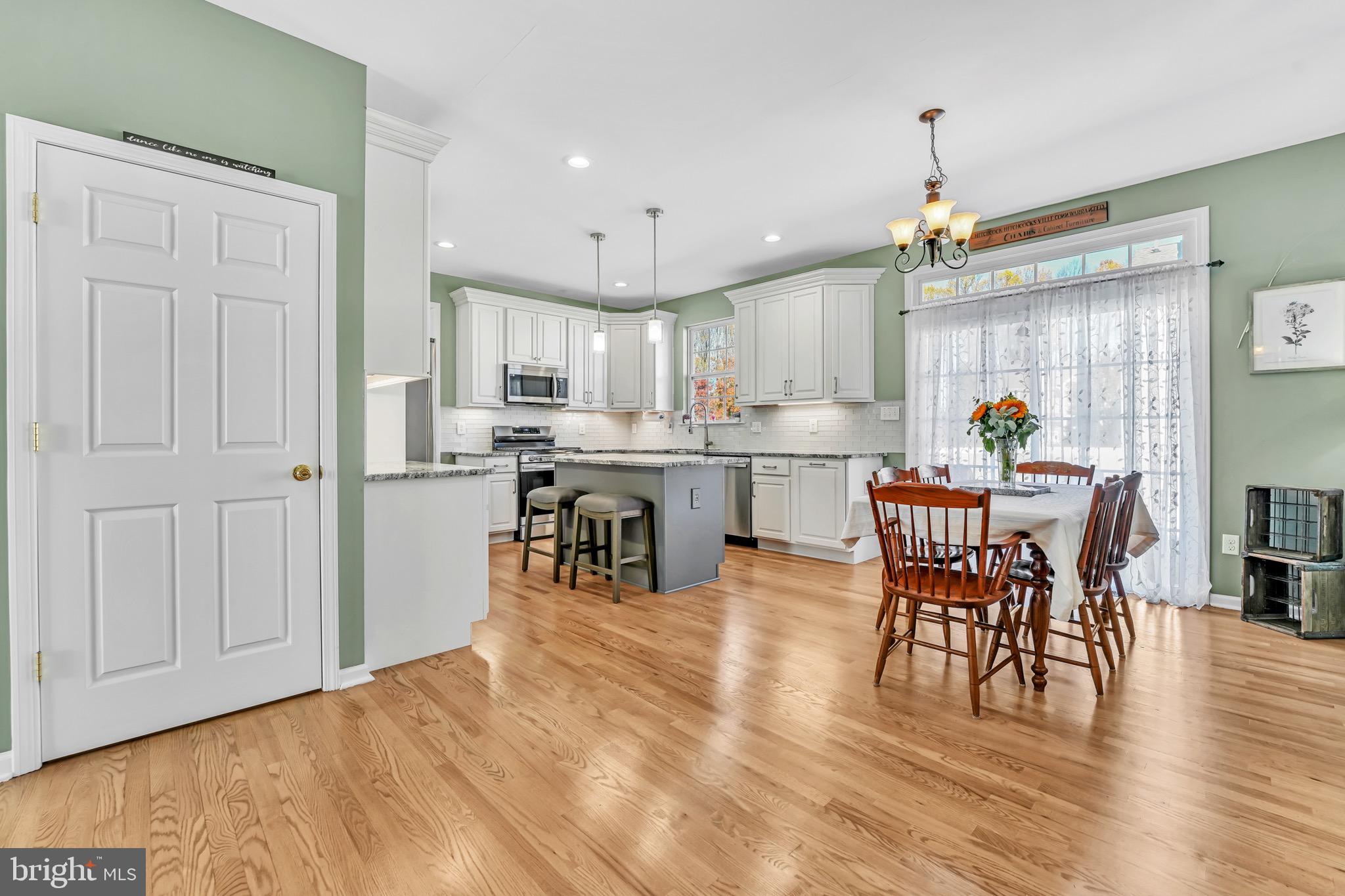 63 Homestead Drive Pemberton, NJ 08068 - Photo 13 of 46 a kitchen with stainless steel appliances a dining table chairs and wooden floor