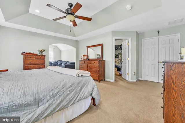 a bedroom with a large bed and a chandelier