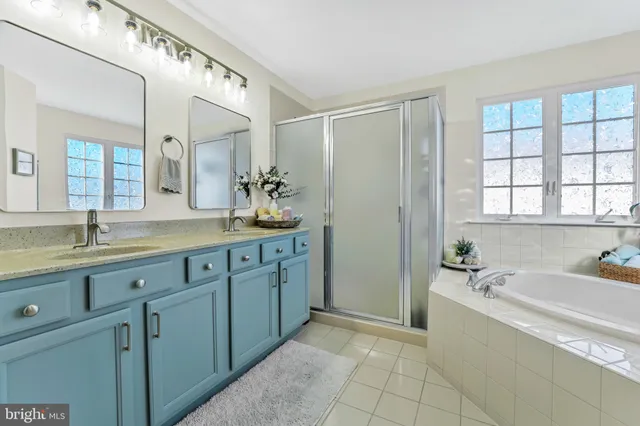 a spacious bathroom with a granite countertop sink mirror and bathtub