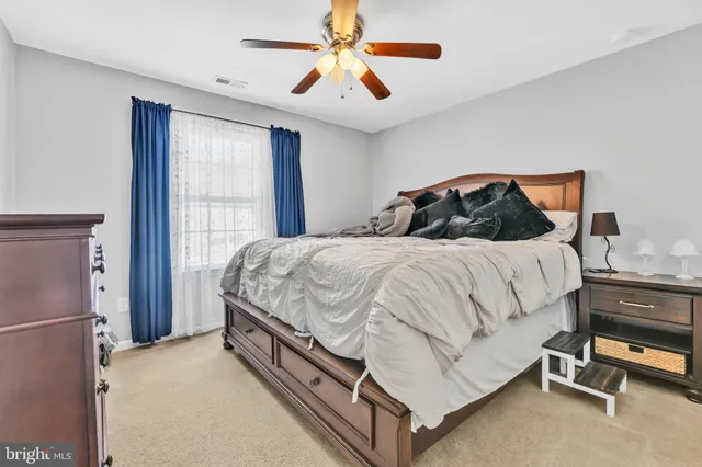 a bedroom with a bed and a ceiling fan