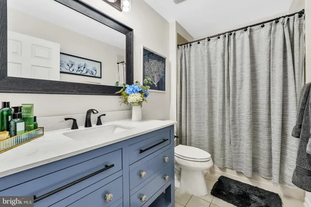 a bathroom with a granite countertop sink vanity mirror and toilet