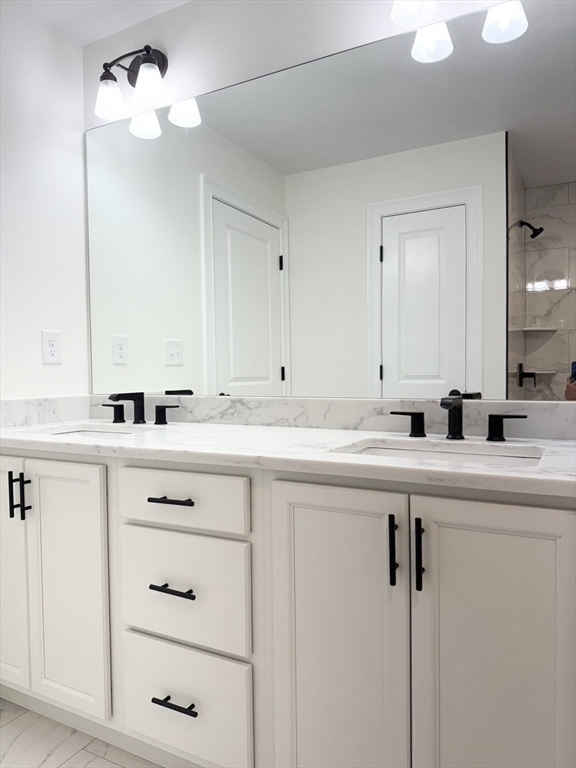 26 Marlyn Road Billerica, MA 01821 - Photo 15 of 36 a sink with white cabinets and a chandelier