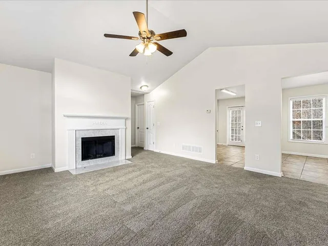 an empty room with windows and fireplace