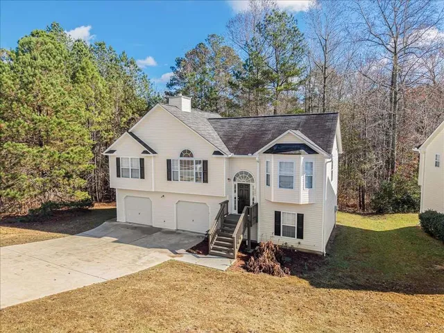 a view of a white house with a yard