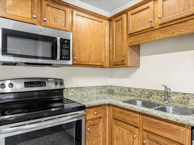 a kitchen with granite countertop a stove and a microwave