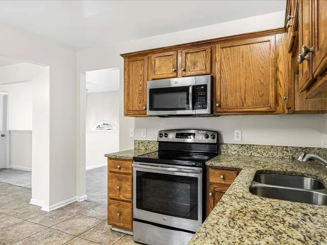 a bathroom with a granite countertop sink a toilet a mirror a bathtub and shower