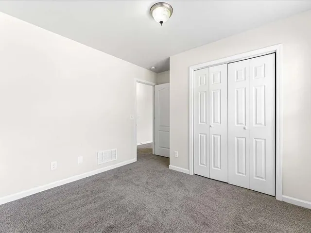 a view of an empty room with a window and a ceiling fan
