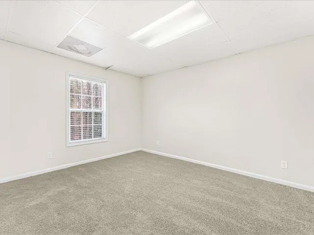 a view of a small space with wooden floor and a window