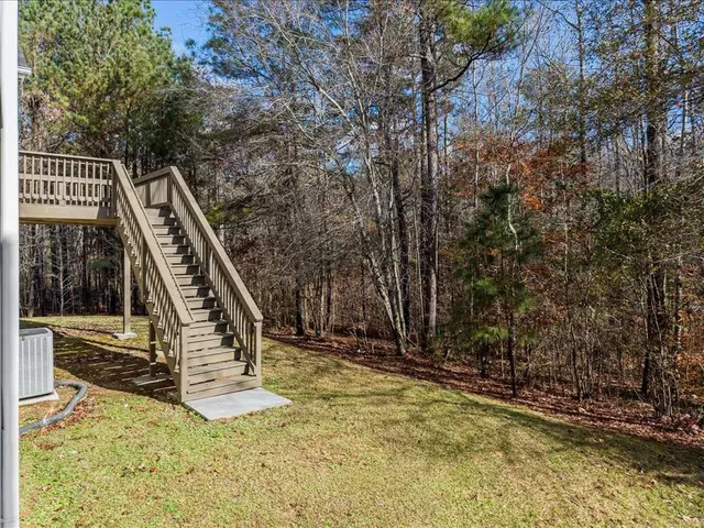 a view of deck with chairs and wooden fence