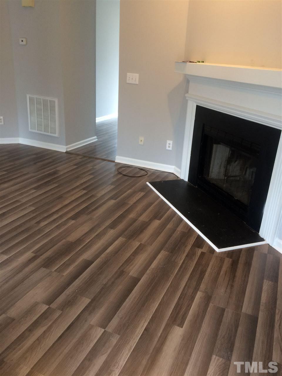 2305 Havering Place Raleigh, NC 27604 - Photo 4 of 10 a view of an empty room with wooden floor and a fireplace