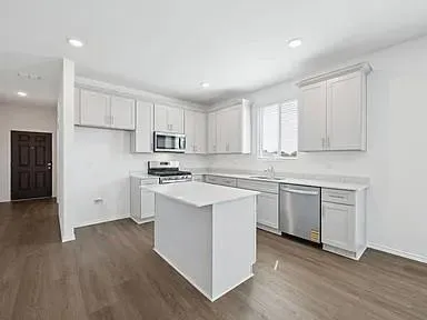 a kitchen with granite countertop white cabinets and white appliances