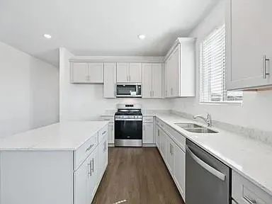 a kitchen with a sink stove top oven and cabinets