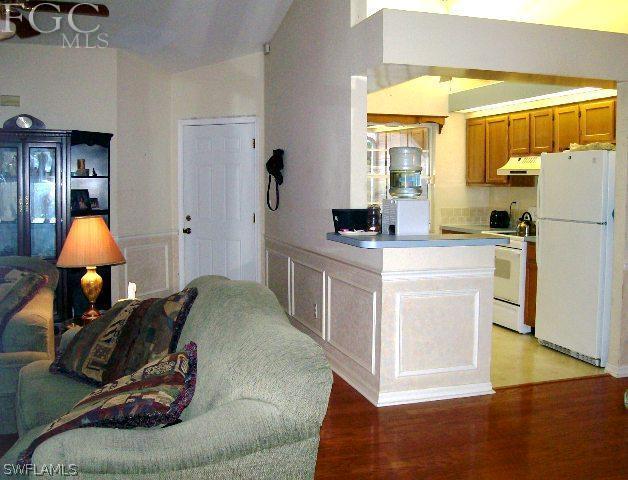 18513 Sunflower Road Fort Myers, FL 33967 - Photo 5 of 14 a workspace with kitchen island white cabinets and a refrigerator