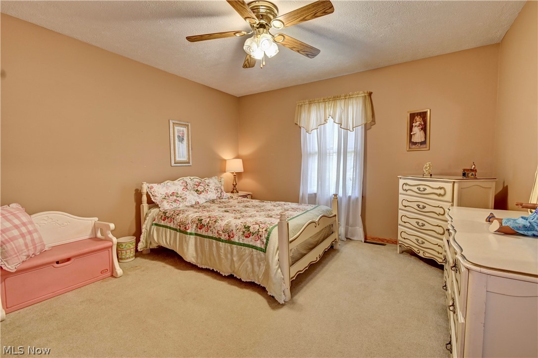 3318 Simpson Road Southeast Dennison, OH 44621 - Photo 18 of 31 Carpeted bedroom with a textured ceiling and ceiling fan