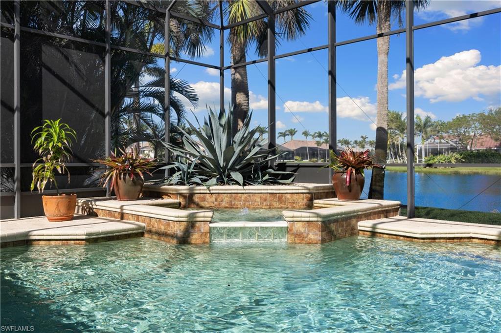 11290 Compass Point Drive Fort Myers, FL 33908 - Photo 42 of 50 a view of a swimming pool with a lawn chairs under an umbrella