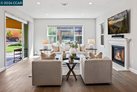 a living room with furniture a flat screen tv and a fireplace