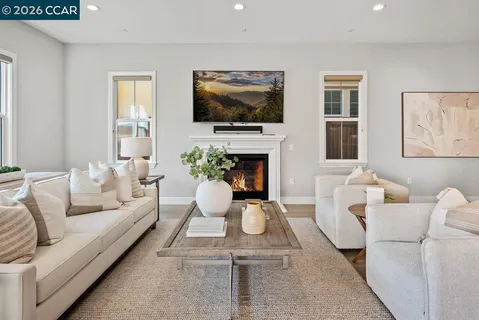 a living room with furniture a flat screen tv and kitchen view