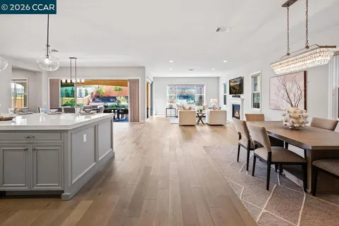 a dining room with furniture a chandelier and wooden floor