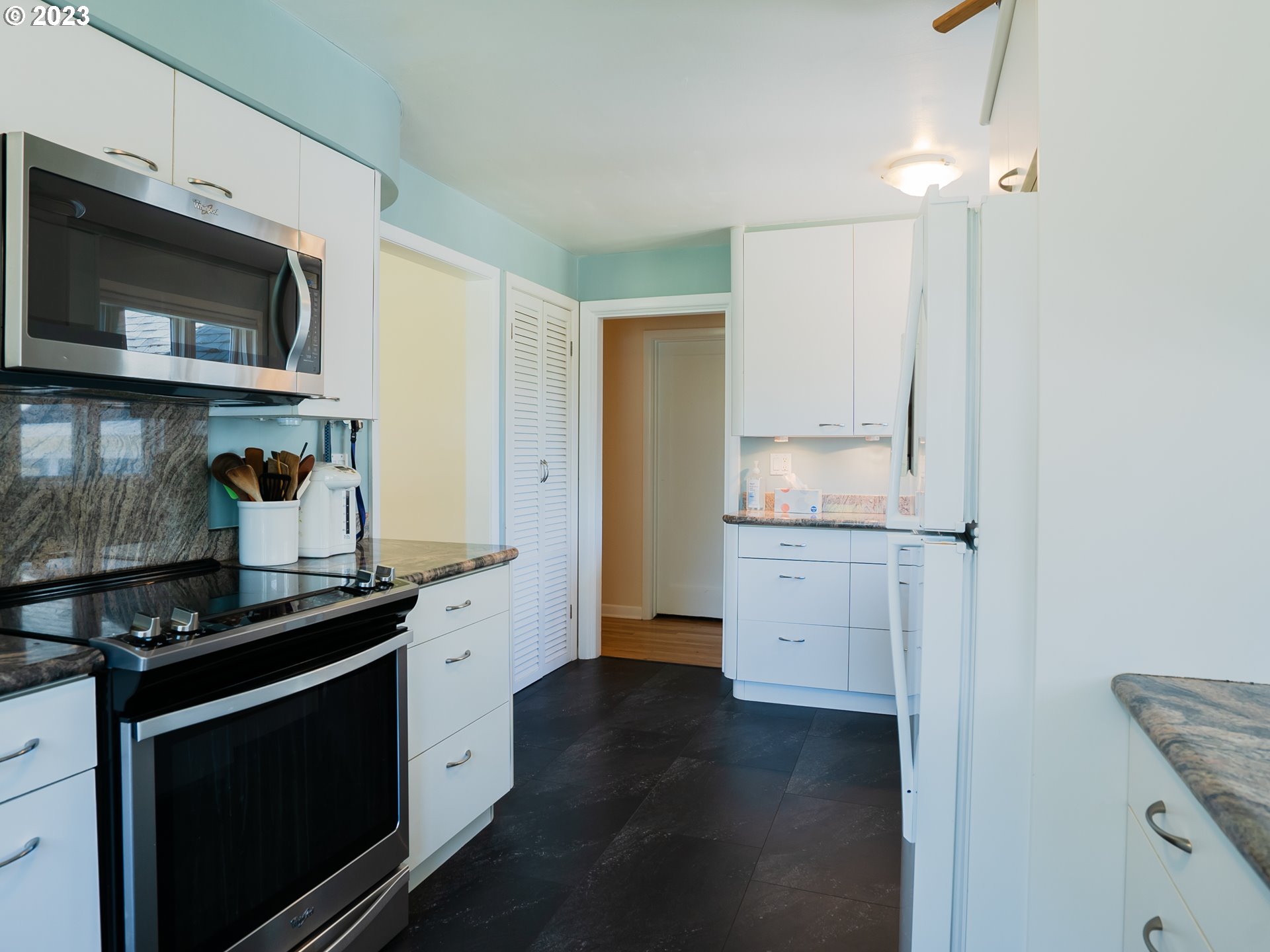 488 Sunshine Acres Drive Eugene, OR 97401 - Photo 15 of 40 a kitchen with granite countertop white cabinets and black appliances