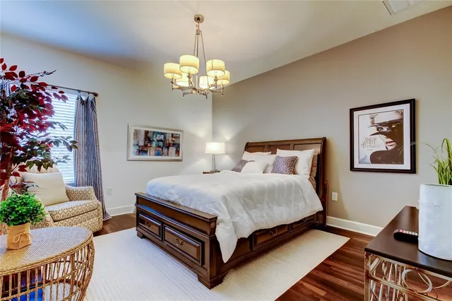a spacious bedroom with a bed and a chandelier