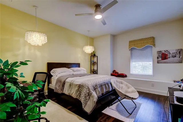 a bedroom with a bed chandelier and a window