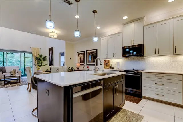 a kitchen with kitchen island a counter space a sink appliances and a counter top space