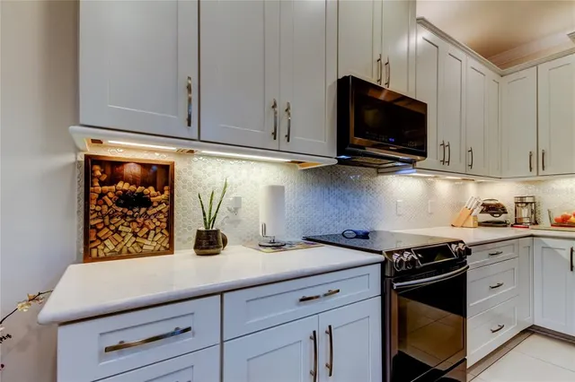 a kitchen with stainless steel appliances granite countertop a sink a stove and microwave with wooden floor
