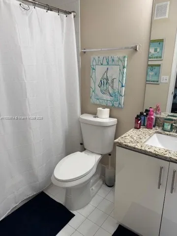 a bathroom with a granite countertop toilet a sink and a shower