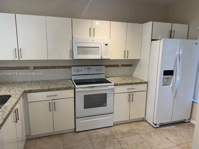 a kitchen with cabinets stainless steel appliances and sink