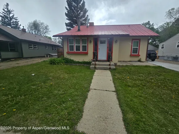 a front view of a house with a garden and yard