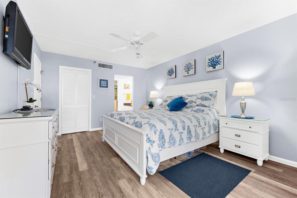 1551 Beach Road, Unit 207 Englewood, FL 34223 - Photo 15 of 40 a bedroom with a large bed and a flat tv screen on dresser