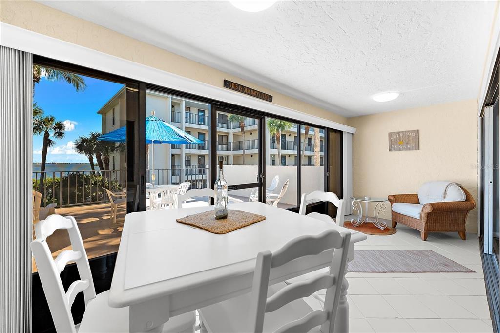 1551 Beach Road, Unit 207 Englewood, FL 34223 - Photo 22 of 40 a view of a dining room with furniture large windows and a chandelier