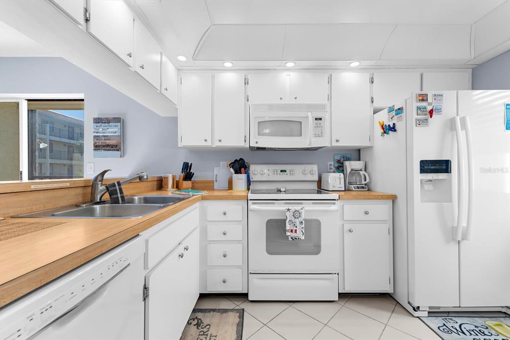 1551 Beach Road, Unit 207 Englewood, FL 34223 - Photo 3 of 40 a kitchen with white cabinets and white appliances