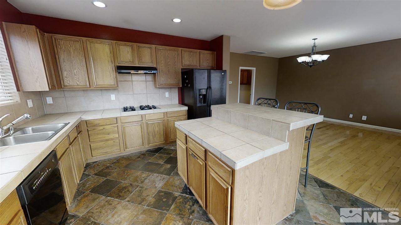 10041 Silver Star Drive Reno, NV 89521 - Photo 8 of 30 a kitchen with a sink a stove and cabinets