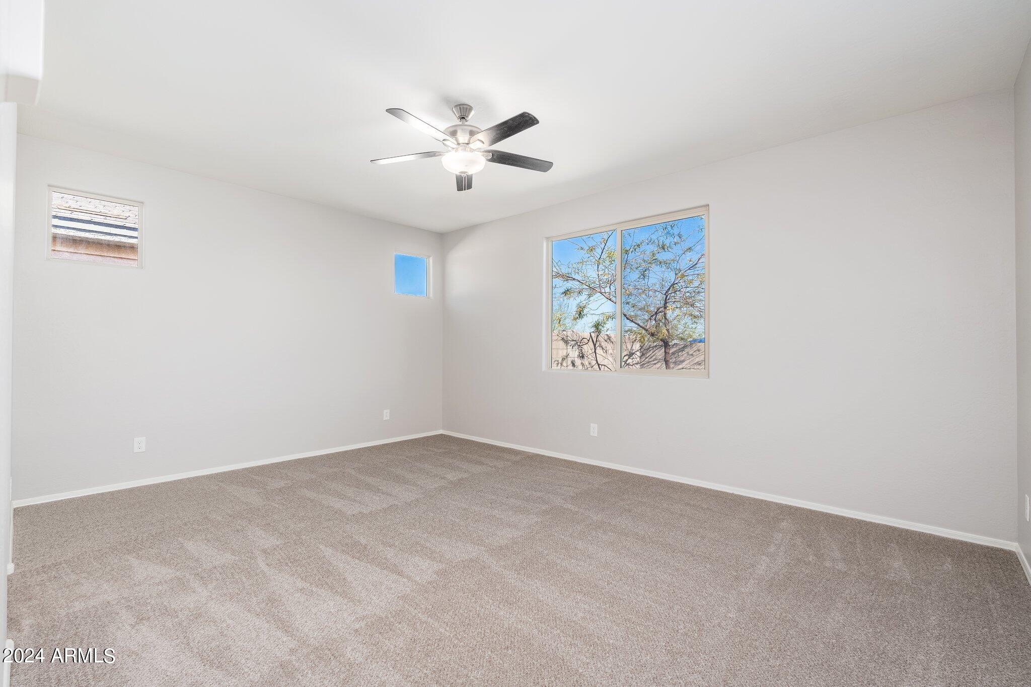 2764 West Apollo Road Phoenix, AZ 85041 - Photo 18 of 45 an empty room with windows and fan