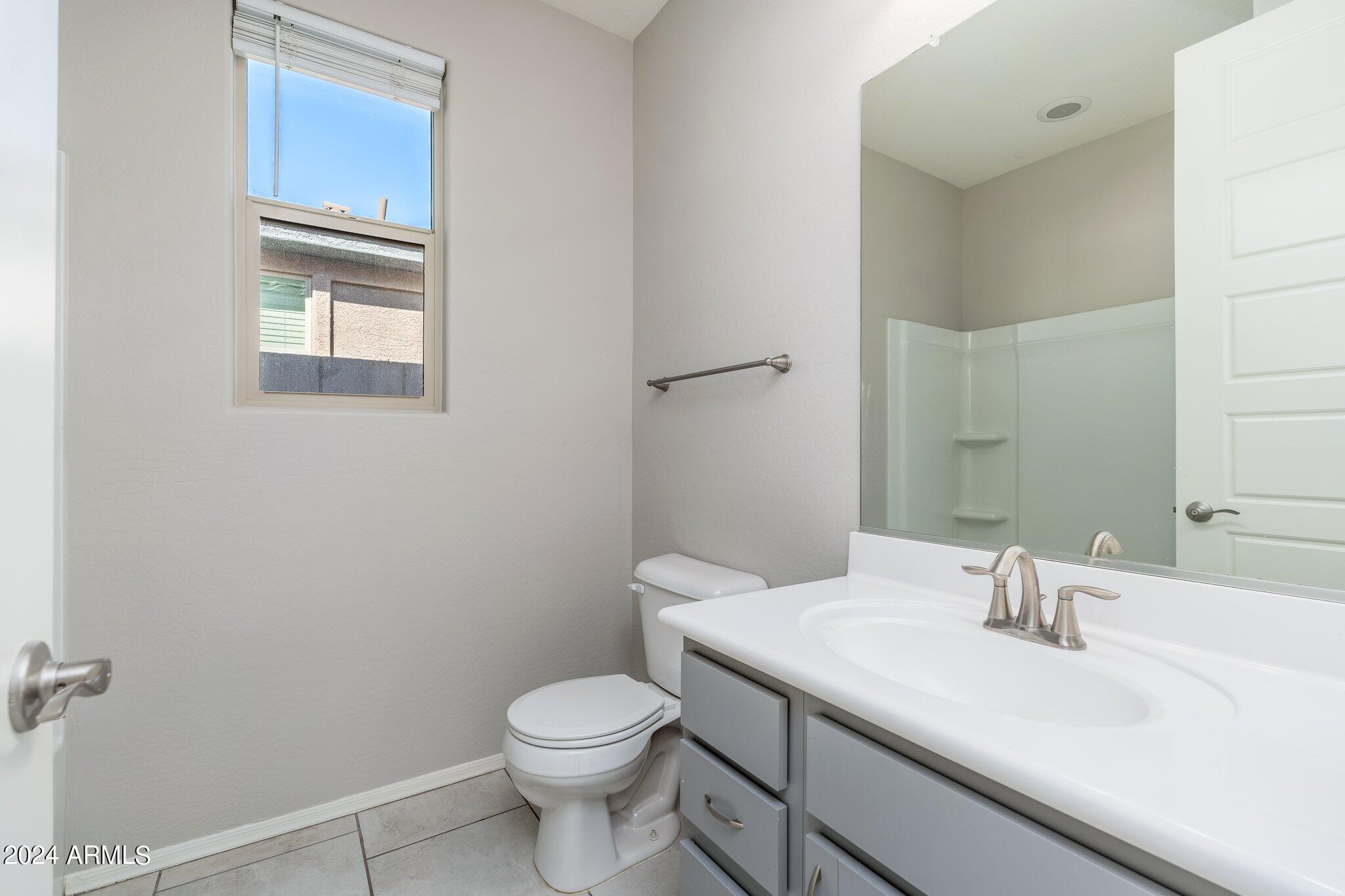 2764 West Apollo Road Phoenix, AZ 85041 - Photo 27 of 45 a bathroom with a sink a toilet and mirror