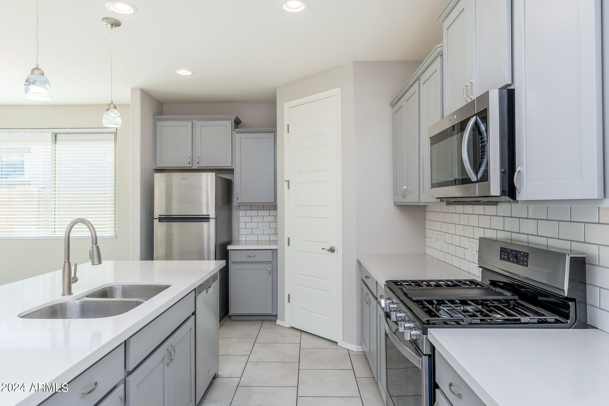 2764 West Apollo Road Phoenix, AZ 85041 - Photo 8 of 45 a kitchen with stainless steel appliances granite countertop a sink stove and refrigerator