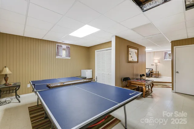 a room with chairs pool table and a refrigerator