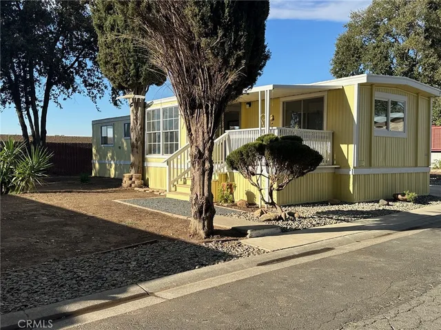 a front view of a house with a tree