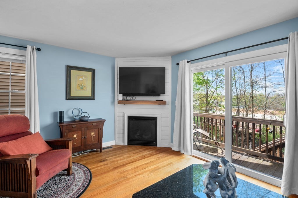28 West Street, Unit 4A Ayer, MA 01432 - Photo 11 of 37 a bedroom with furniture a flat screen tv and a fireplace