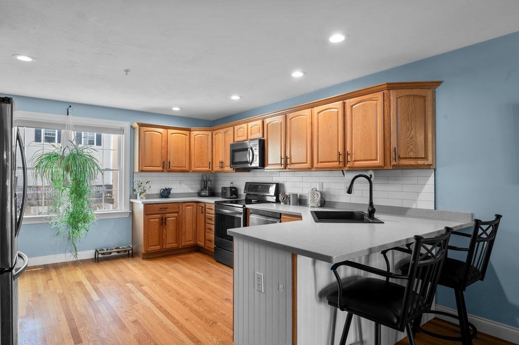 28 West Street, Unit 4A Ayer, MA 01432 - Photo 6 of 37 a kitchen with a sink and wooden cabinets