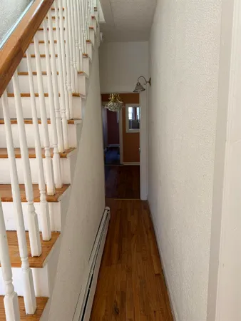 a view of a hallway with wooden floor and staircase
