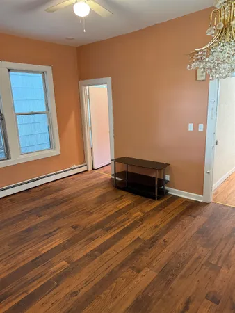 a view of room with wooden floor and chandelier
