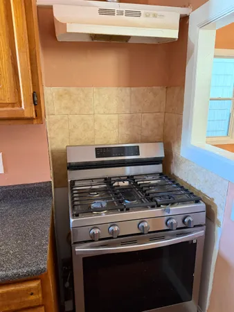 a stove top oven sitting inside of a kitchen
