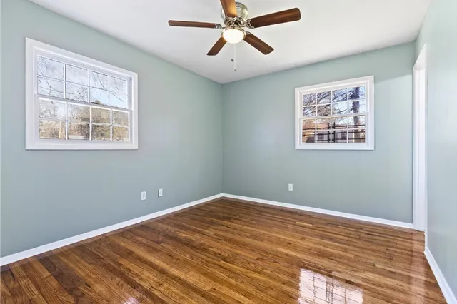 a view of a big room with wooden floor and windows
