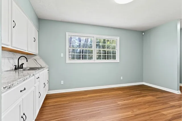 a view of a kitchen with wooden floor and a sink