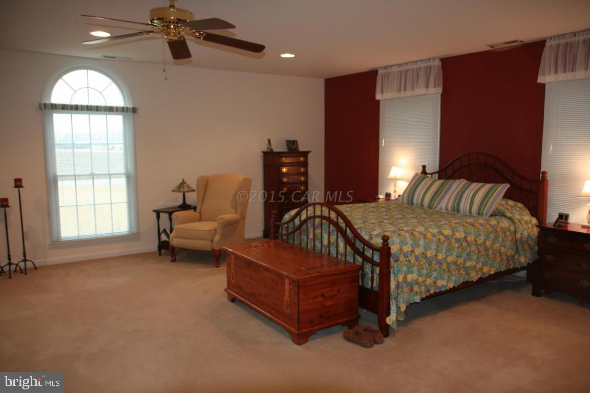 5607 Lone Pine Road Rhodesdale, MD 21659 - Photo 13 of 38 a spacious bedroom with a bed and a chandelier