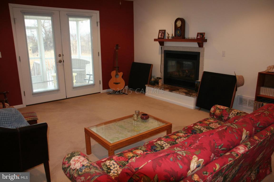 5607 Lone Pine Road Rhodesdale, MD 21659 - Photo 8 of 38 a living room with furniture a fireplace and a flat screen tv
