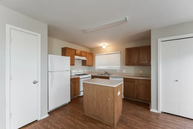 a kitchen with a sink a stove a refrigerator and cabinets