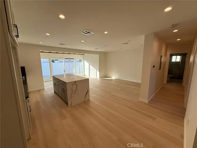 a large kitchen with granite countertop a large counter top stainless steel appliances and cabinets